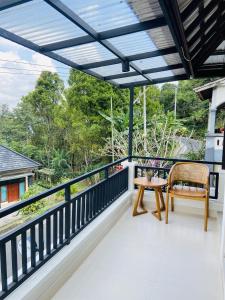 a view from the balcony of a house with a chair and a table at PARAWIYA Villa in Munduk