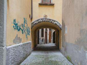 an alley with an arch in a building with graffiti at Apartment near Lake Maggiore and Borromean Isles in Intra