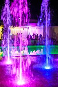 eine Gruppe von Wasserfontänen mit violetten und grünen Lichtern in der Unterkunft Hotel Melodia in Venus + 109 Fotos