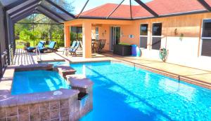 una piscina in un cortile con una casa di "Blue Diamond" heated pool house by the water a Cape Coral