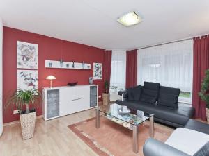 a living room with a black couch and red walls at Wohnung in Nieheim am Waldrand in Nieheim