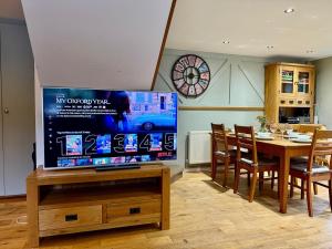a dining room with a large tv on a table at 2Bed Cottage Near Odiham Castle Scenic Field Views in Greywell