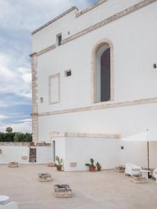 a white building with chairs and a table at GH Masseria Monet in Monopoli