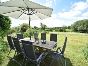 a wooden table and chairs with an umbrella at Lovely mansion with fenced garden in Baguer-Morvan +33 photos