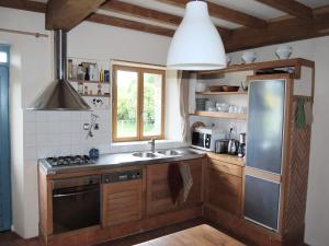 a kitchen with a stainless steel refrigerator and a sink at Lovely mansion with fenced garden in Baguer-Morvan