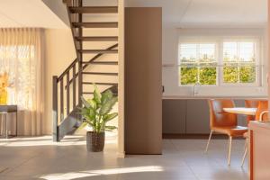 a kitchen and dining room with a staircase in a house at Beachvilla Royaal met Sauna - 10 personen in Holle Poarte