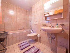 a bathroom with a sink and a toilet and a tub at Duplexwohnung in den Alpen in Riederalp