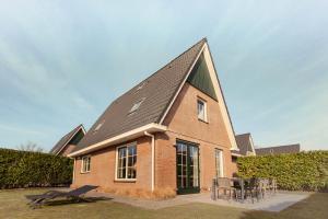 a large brick building with a pitched roof at Beachvilla Royaal met Sauna - 10 personen in Holle Poarte