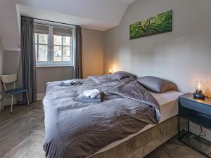 a large bed in a bedroom with a window at Farmhouse Nijverdal near Sallandse Heuvelrug in Nijverdal