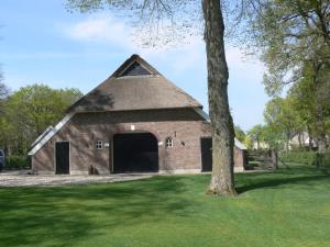 an old brick barn with a thatched roof at Farmhouse Nijverdal near Sallandse Heuvelrug in Nijverdal