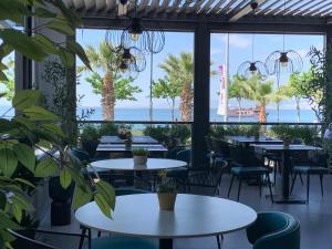 a restaurant with tables and chairs and a view of the ocean at RUKA Hotel in Narlıdere +89 photos
