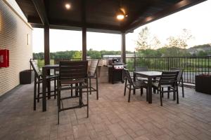 a patio with tables and chairs and a grill at Candlewood Suites Middletown - Goshen by IHG in Middletown