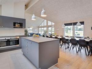 a large kitchen with a long table and chairs at 5 star holiday home in Grenaa in Grenå
