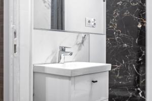 un bagno con lavandino e specchio di Złota 77 by NYX Apart a Skorka Altre 15 foto