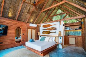a bedroom with a bed in a room with wooden ceilings at Casa Iwana Tayrona Suites Deluxe Playa y AC in Guachaca +62 photos