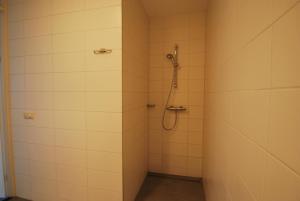 a bathroom with a shower with white tiled walls at Beachvilla Royaal Classic met Sauna - 10 personen in Holle Poarte +16 photos