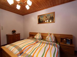 a bedroom with a bed and a painting on the wall at Apartment Sulzau near Wildkogel Ski Slopes in Neukirchen am Großvenediger