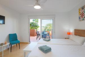 biała sypialnia z łóżkiem, stołem i krzesłami w obiekcie Appartement La Casa Soleada Mar Menor Golf & Padel Resort w mieście Torre-Pacheco +32 zdjęcia
