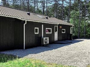 a small black building with a tv in front of it at 8 person holiday home in Rødby-By Traum in Rødby