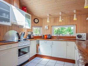 a kitchen with white appliances and a clock on the wall at 8 person holiday home in Rødby-By Traum in Rødby +26 photos