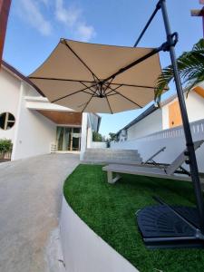 Nathon BayにあるVilla Sanam Binhの家の前のベンチと傘