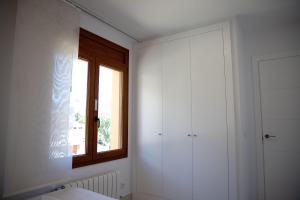 Baño blanco con ventana y aseo en Villa Casa Calonge, en Calonge
