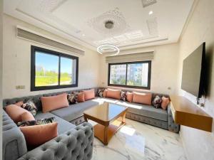 a living room with a couch and a tv at Yaluna Appart'hôtel & Restaurant in Tangier