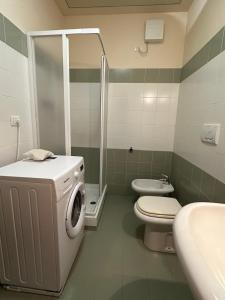 a bathroom with a washing machine and a toilet at Casa di Pably in Puntone di Scarlino +17 photos