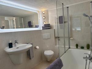 a bathroom with a sink and a toilet and a shower at Ferienhaus in Rostock - Brinckmansdorf in Rostock +14 photos