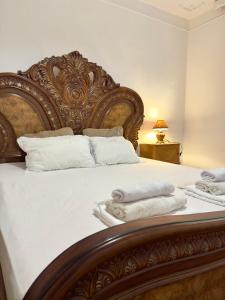 a bedroom with a large wooden bed with towels on it at Davit's Apartments 21 in Tbilisi City