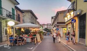 a group of people walking down a street with restaurants at Casa di Alessandro in Marina di Massa
