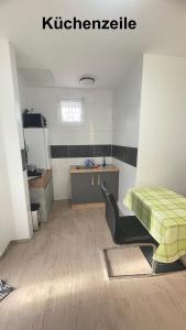 a room with a kitchen with a bed and a desk at Kim Homestay B Zimmer 1 in Sömmerda