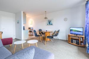 a living room with a couch and a table and a tv at Sünnslag Wohnung 049 in Boltenhagen