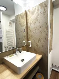 a bathroom with a white sink and a mirror at Les appartements du Clos de la Chartreuse By Ateya in Aix-en-Provence