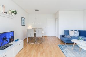 a living room with a blue couch and a table at Sünnslag Wohnung 113 in Boltenhagen