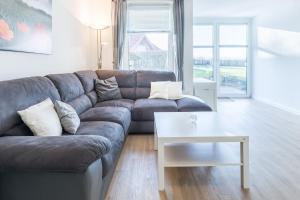 a living room with a couch and a table at Sünnslag Wohnung 114 in Boltenhagen