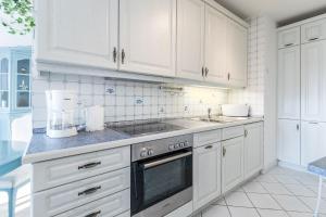 a kitchen with white cabinets and a stove top oven at Sünnslag Wohnung 114 in Boltenhagen