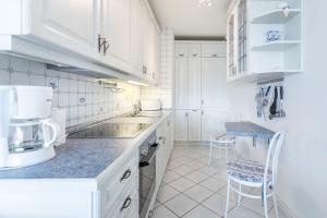 a white kitchen with a sink and a counter at Sünnslag Wohnung 114 in Boltenhagen