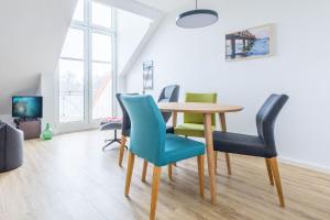 a dining room with a table and chairs at Sünnslag Wohnung 129 in Boltenhagen