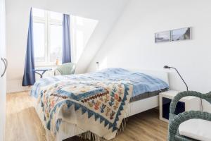 a white bedroom with a bed and a window at Sünnslag Wohnung 129 in Boltenhagen