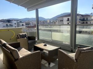 a balcony with chairs and a table and large windows at Skye urban oasis in Tripolis