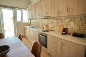 a kitchen with wooden cabinets and a table and a counter top at Skye urban oasis in Tripoli