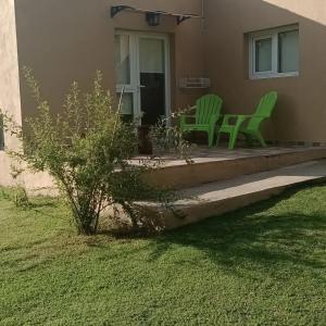 dos sillas verdes sentadas en el porche de una casa en Cabaña Ruca Malen, en Tandil 6 fotos más