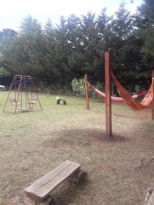 un parque infantil con columpio y hamaca en Cabaña Ruca Malen, en Tandil