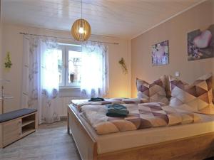 a bedroom with a large bed and a window at Gemütliche Wohnung für 4 Personen in Medebach