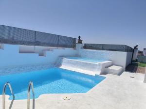 a swimming pool with blue water and stairs on a building at La Morada de Eva in Ronda