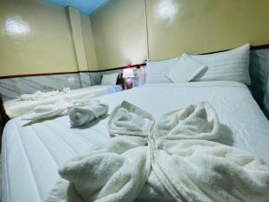 a white bed with white towels on it at Residencia abuelita Carmen in Mindo