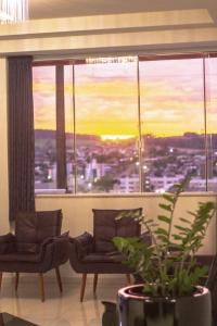 a room with two chairs and a large window at LH Plaza Hotel in Chapecó