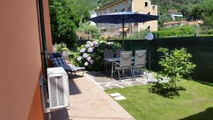 une terrasse avec une table, des chaises et un parasol dans l'établissement Appartamento Tramontana, à Deiva Marina