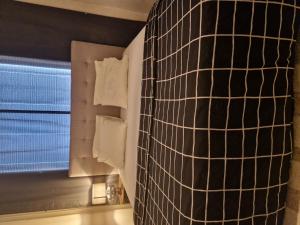 a bathroom with a tiled wall and a window at Relax in Lahtis Cozy Apartment in Lahti